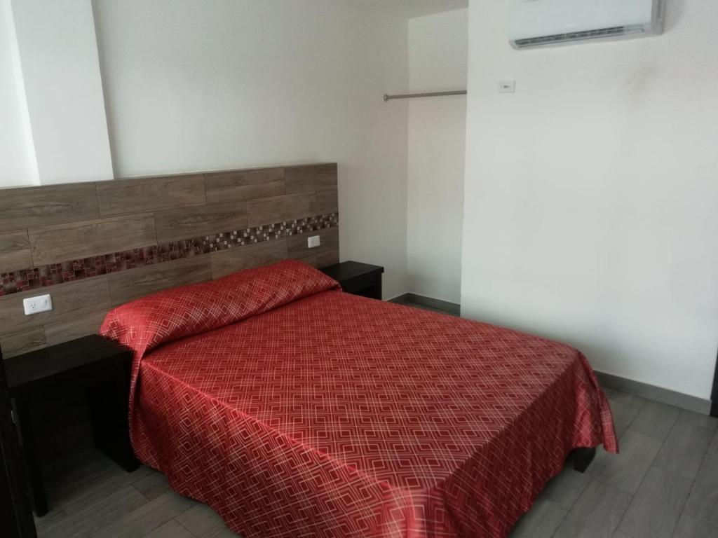 1 dormitorio con 1 cama con edredón rojo en HOTEL QUINTERO, en Teapa