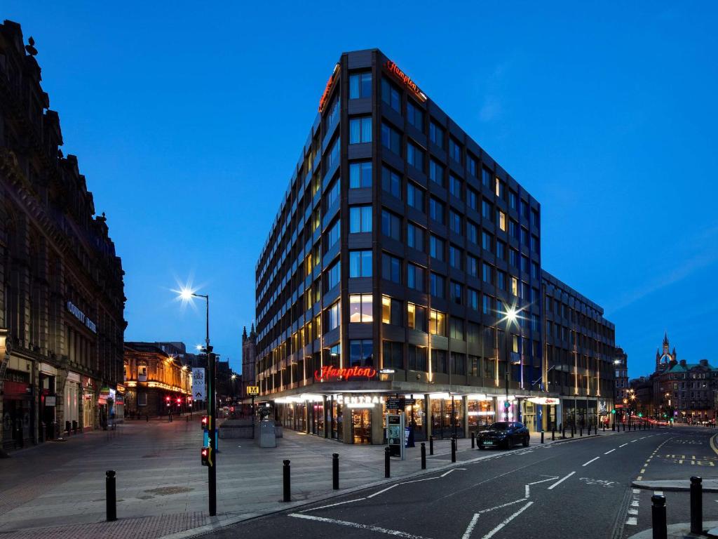 un grand bâtiment sur une rue de la ville la nuit dans l'établissement Hampton by Hilton Newcastle, à Newcastle upon Tyne