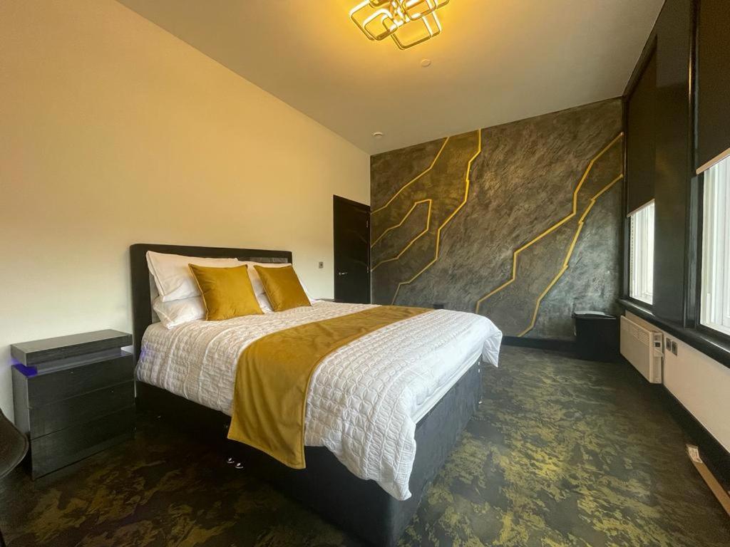 um quarto com uma cama grande e almofadas amarelas em Centenary Apartments em Bradford