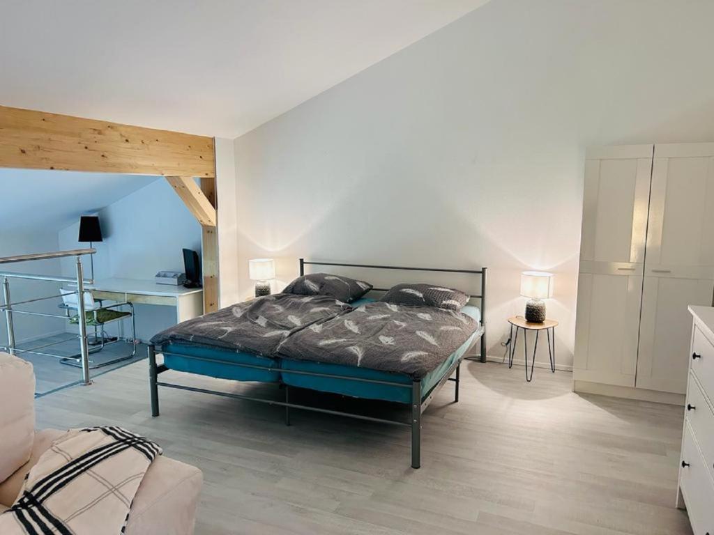 a bedroom with a bed and a desk in it at Moderne Maisonettewohnung/2 Zimmer/Küche/Bad #1 in Markt Schwaben