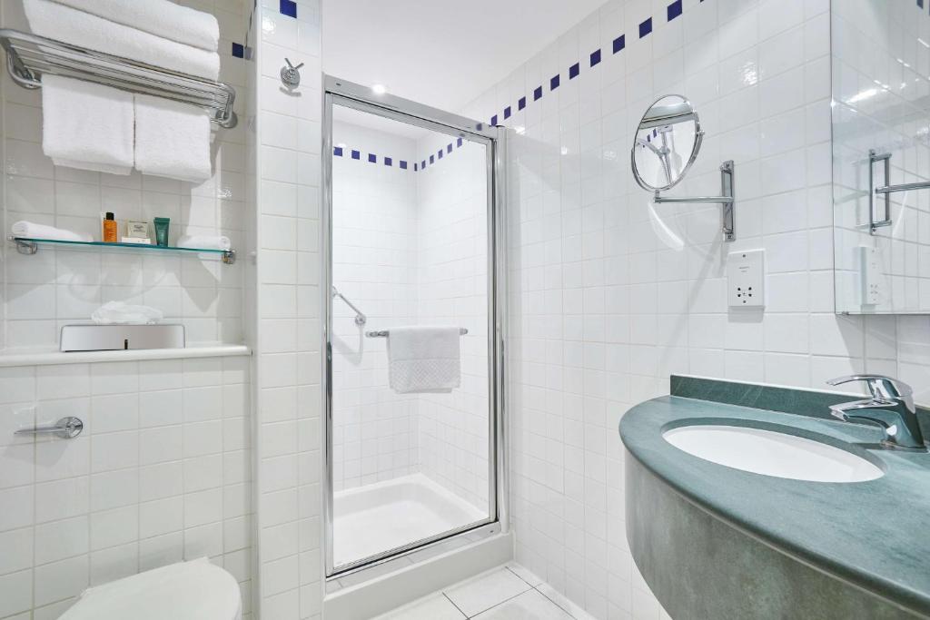 a white bathroom with a sink and a shower at Hilton Garden Inn Birmingham Brindley Place in Birmingham