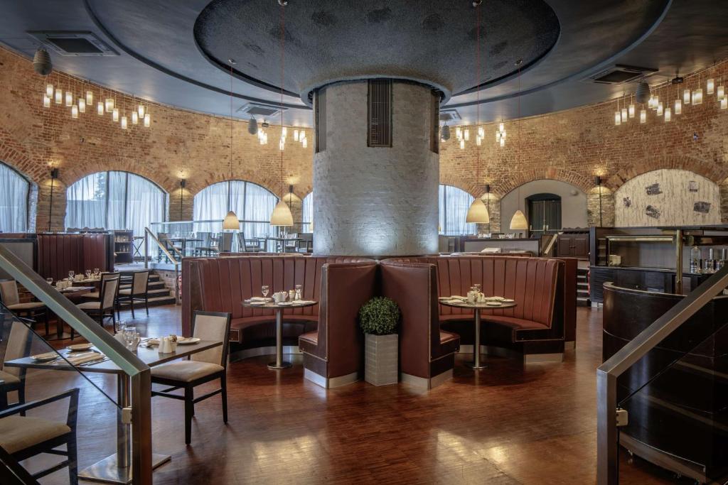 a restaurant with tables and chairs in a room with brick walls at DoubleTree by Hilton Bristol City Centre in Bristol