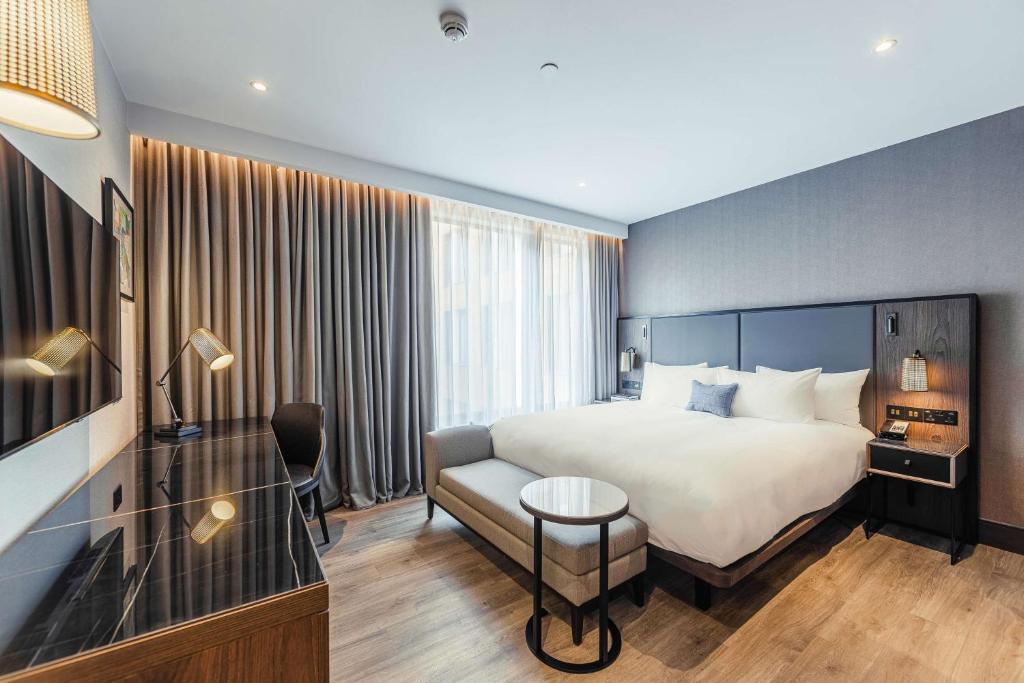 Een bed of bedden in een kamer bij The Fellows House Cambridge, Curio Collection By Hilton