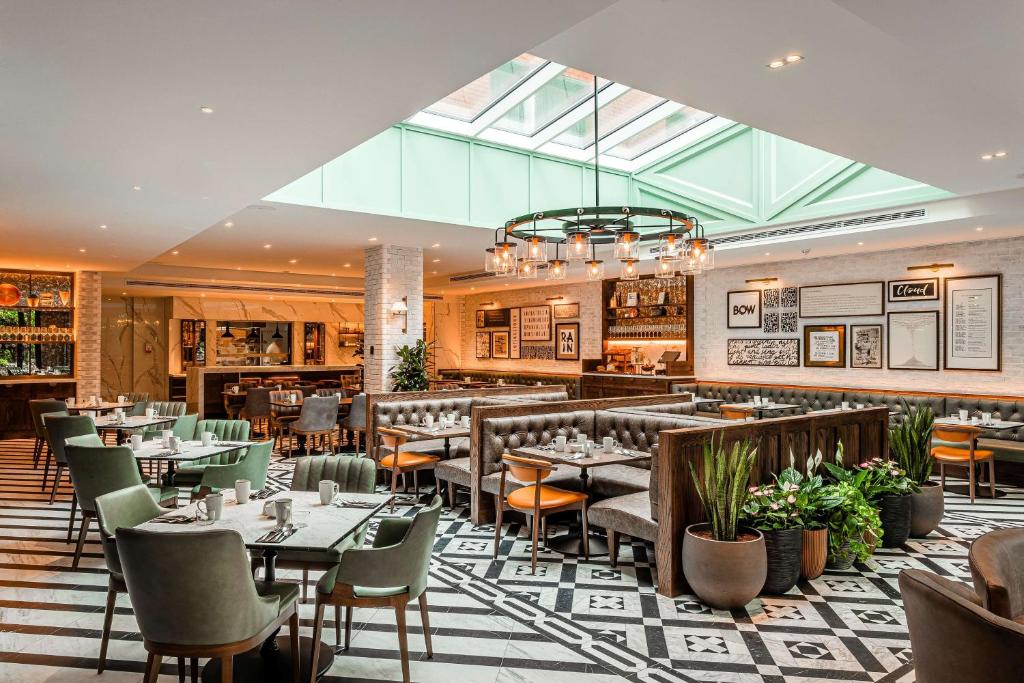 een restaurant met tafels en stoelen en een glazen plafond bij The Fellows House Cambridge, Curio Collection By Hilton in Cambridge
