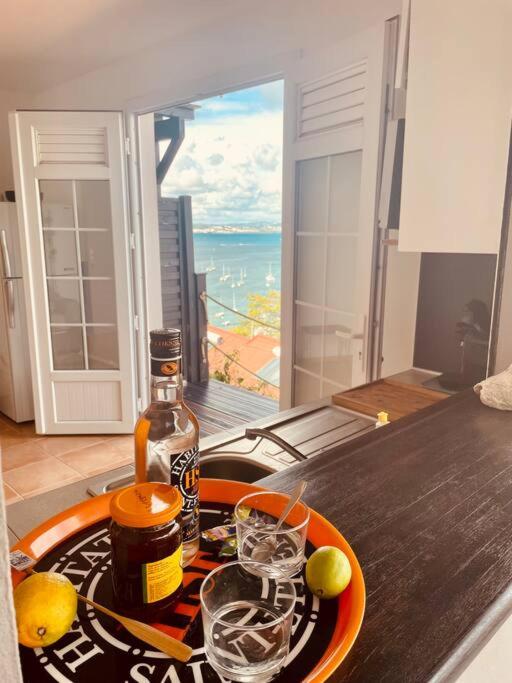 a table with a bottle of alcohol and glasses on it at L'amour à la plage...vue mer exceptionnelle ! in Les Trois-Îlets