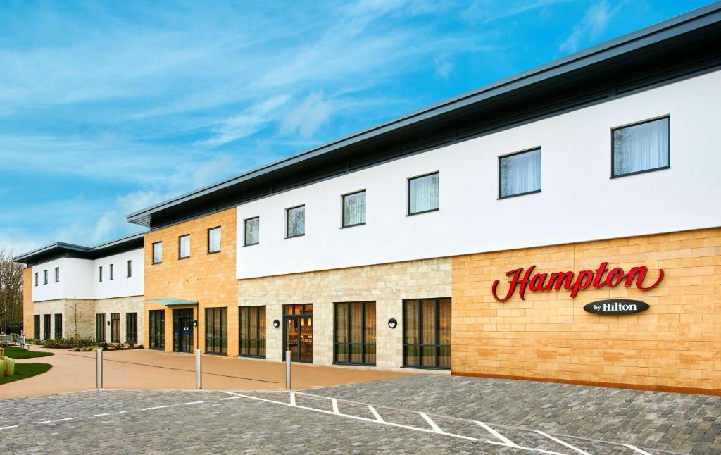 un bâtiment avec une enseigne de pharmacie sur le côté dans l'établissement Hampton by Hilton Oxford, à Oxford