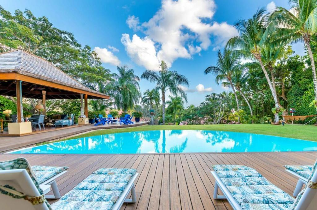 uma piscina com duas espreguiçadeiras ao lado de um resort em Sunny Vacation Villa No 71 em San Rafael del Yuma