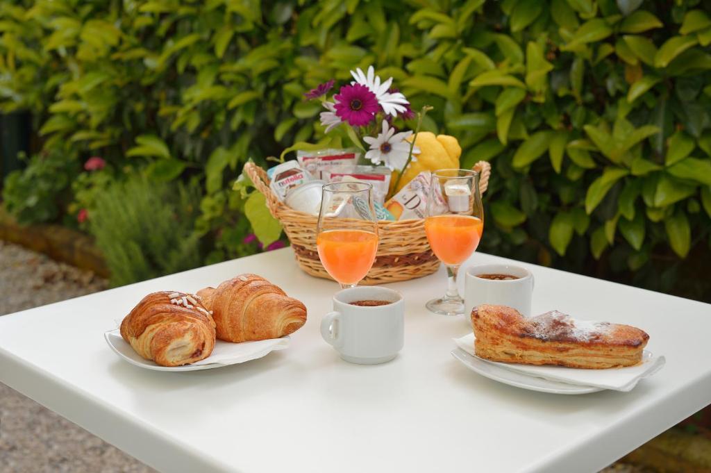 a table with a breakfast of croissants and orange juice at La Capannina in Procida