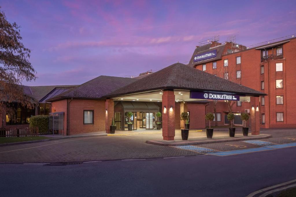 a building on a street in front of a building at DoubleTree by Hilton Manchester Airport in Hale