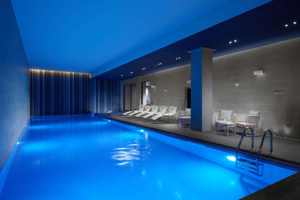a swimming pool with blue lights in a hotel at Hilton London Bankside in London
