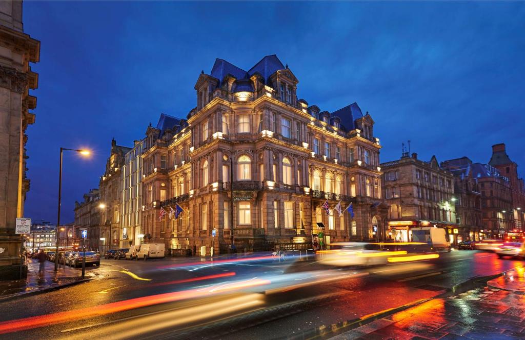 ein Gebäude in einer belebten Straße nachts in der Unterkunft DoubleTree by Hilton Hotel & Spa Liverpool in Liverpool