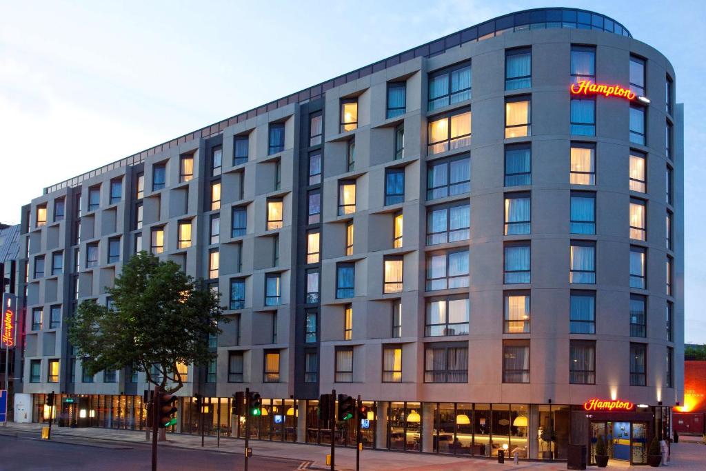 un gran edificio gris con luces encendidas en Hampton by Hilton London Waterloo en Londres