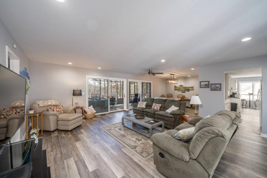 ein großes Wohnzimmer mit Sofas und Fernseher in der Unterkunft Golfers Getaway in Hot Springs Village