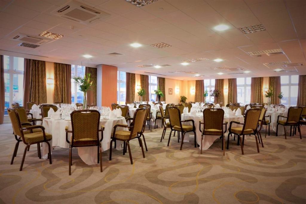 a banquet hall with white tables and chairs at Holiday Inn Kenilworth - Warwick by IHG in Kenilworth