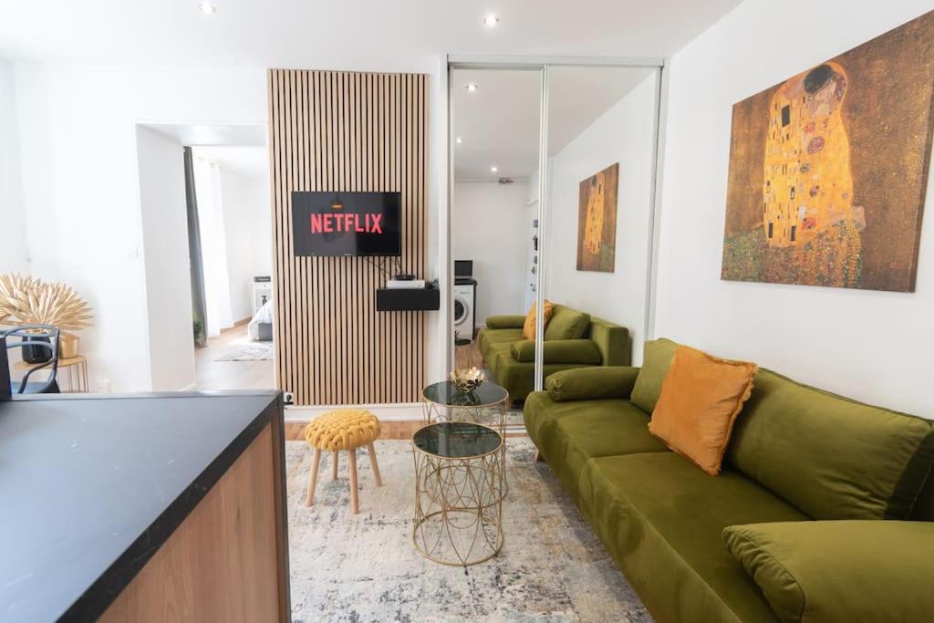 uma sala de estar com um sofá verde e um balcão em Parisian & Chic Appartement -15 min from Paris Center em Ivry-sur-Seine
