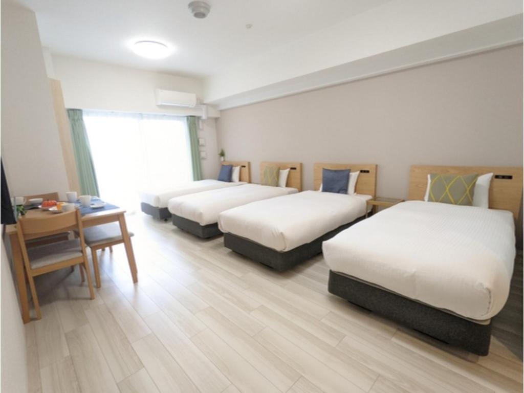 a hotel room with three beds and a table at ESLEAD HOTEL Namba Daikokucho - Vacation STAY 86025v in Osaka