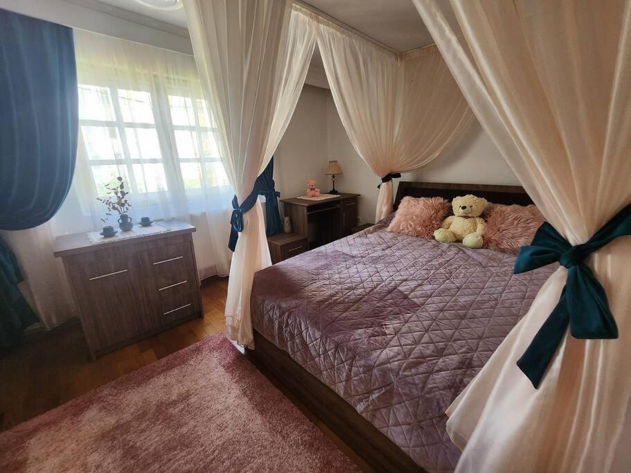 um urso de peluche sentado numa cama num quarto em Apartament liniștit La Pădure em Piteşti