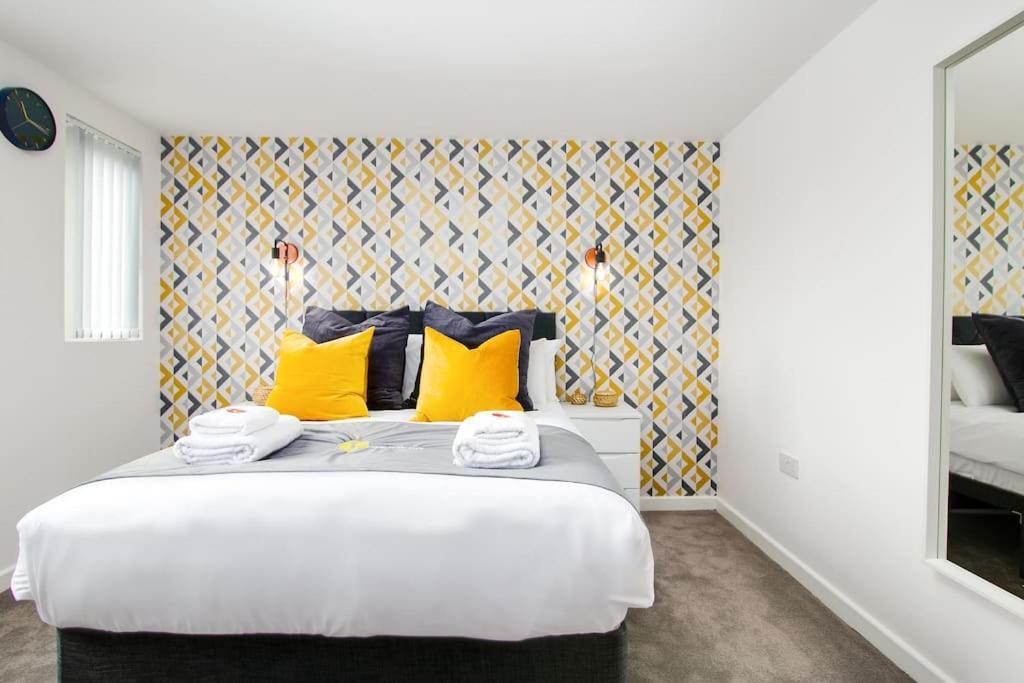 a bedroom with a large bed with yellow pillows at SCA - Luxurious Studio - VS5 in Wolverhampton