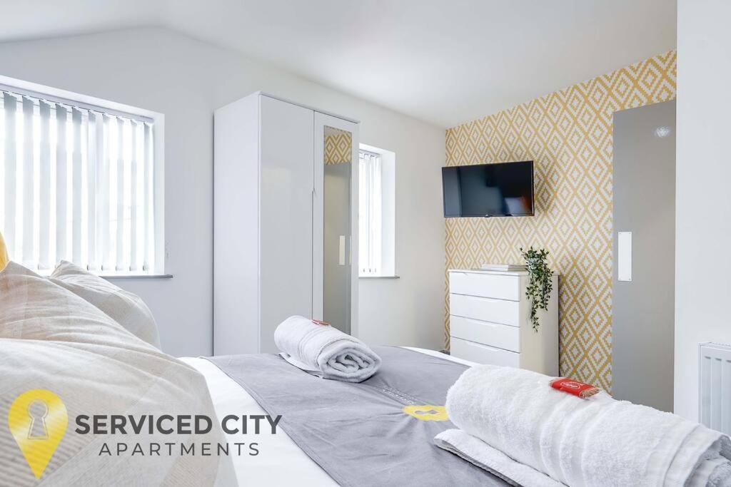 een slaapkamer met een bed met handdoeken erop bij SCA - Perfect City Studio - VS7 in Wolverhampton