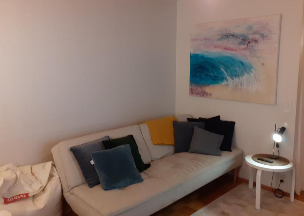 sala de estar con sofá blanco y almohadas azules en Ann's terraced house with sauna en Vantaa