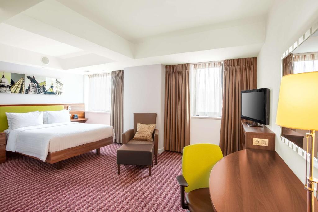 a hotel room with a bed and a tv at Hampton by Hilton Cluj-Napoca in Cluj-Napoca