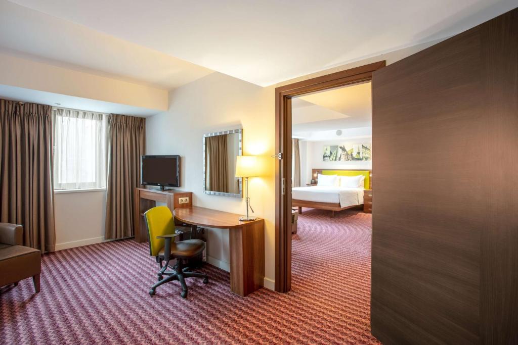 a hotel room with a desk and a bed at Hampton by Hilton Cluj-Napoca in Cluj-Napoca