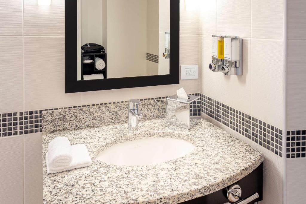 a bathroom with a sink and a mirror at Hampton by Hilton Cluj-Napoca in Cluj-Napoca
