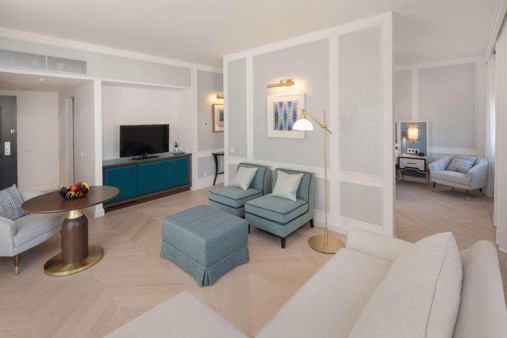 a living room with a couch and chairs and a tv at Hilton Imperial Dubrovnik in Dubrovnik