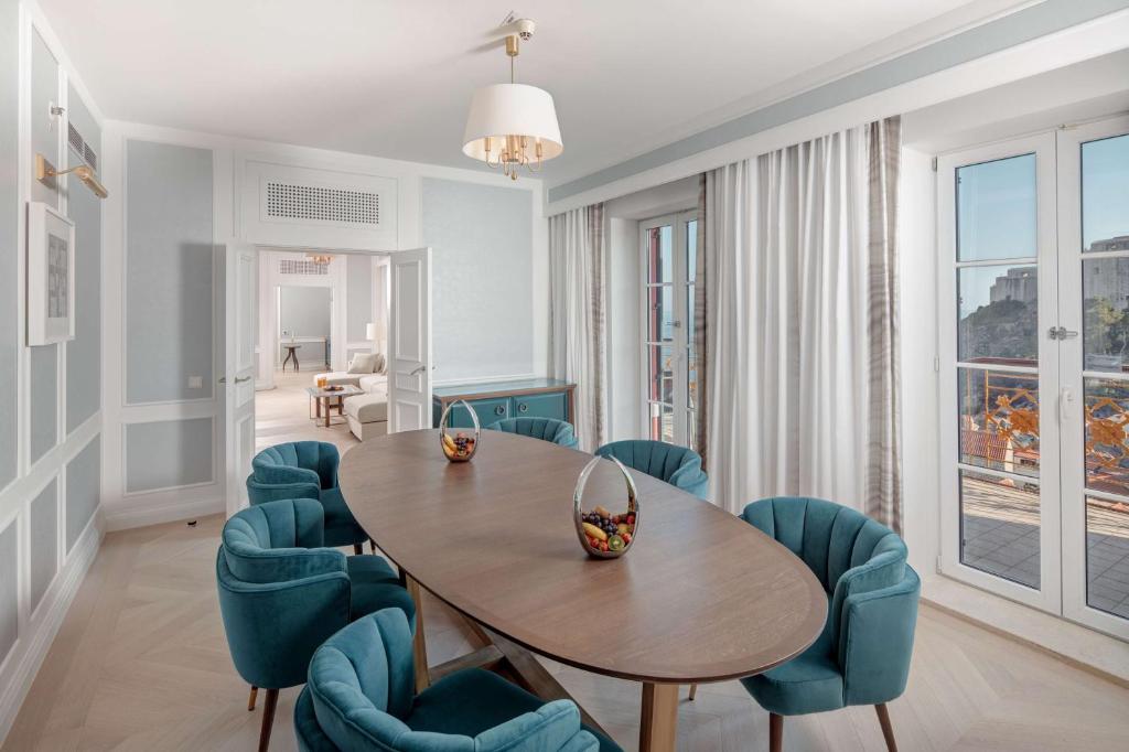a dining room with a table and blue chairs at Hilton Imperial Dubrovnik in Dubrovnik