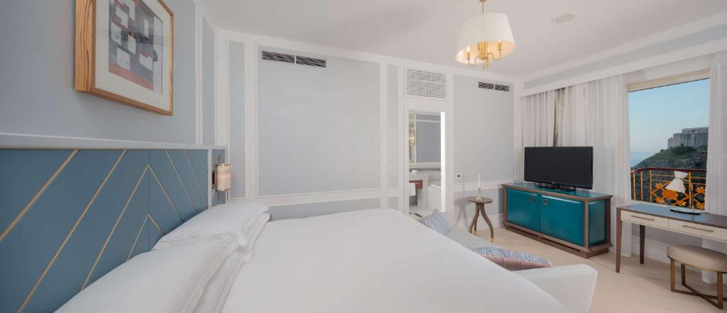 a bedroom with a white bed and a television at Hilton Imperial Dubrovnik in Dubrovnik