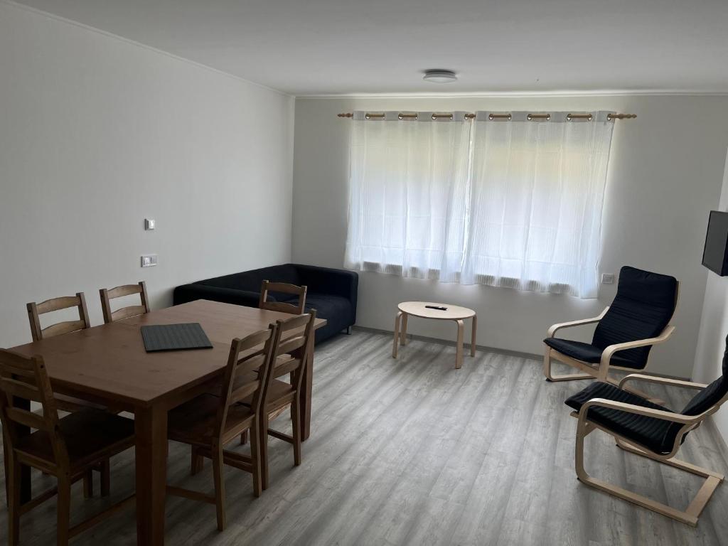 a living room with a table and chairs and a couch at Kozákov Apartmány - první patro 