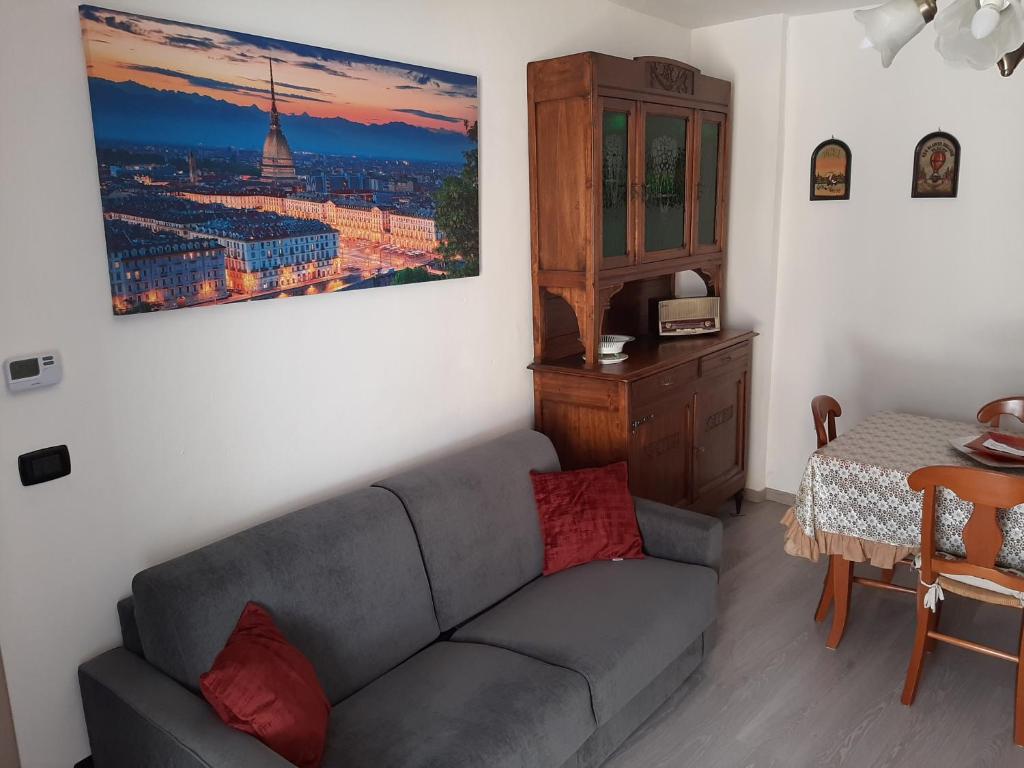 a living room with a couch and a painting on the wall at House Vittone Venaria Reale in Venaria Reale