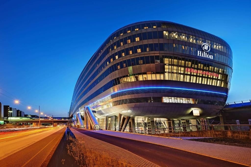 un grand bâtiment avec beaucoup de fenêtres la nuit dans l'établissement Hilton Frankfurt Airport, à Francfort-sur-le-Main