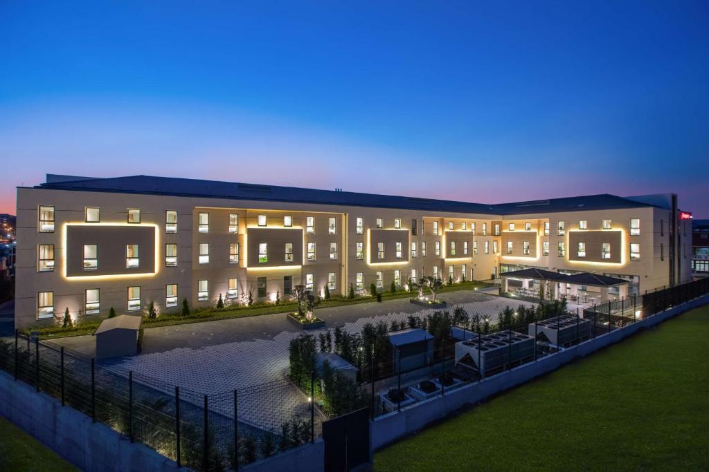 a large building with a courtyard at night at Hampton by Hilton Istanbul Zeytinburnu in Istanbul