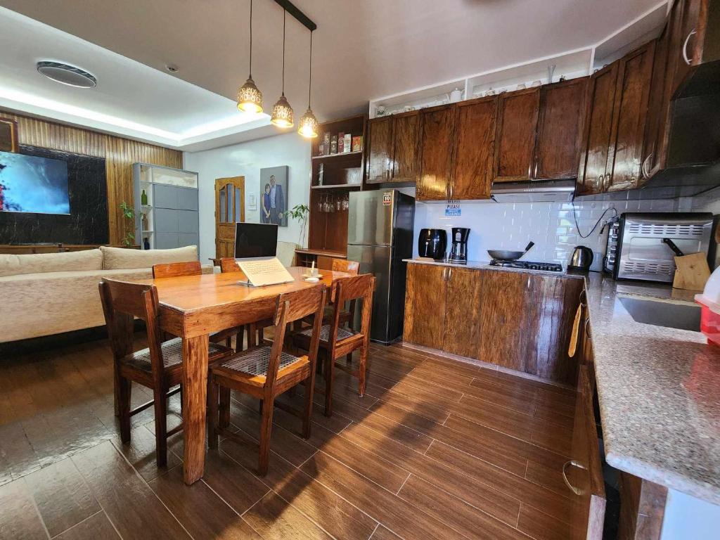 eine Küche und ein Wohnzimmer mit einem Holztisch und Stühlen in der Unterkunft Lorenzo's Homestay in Basco