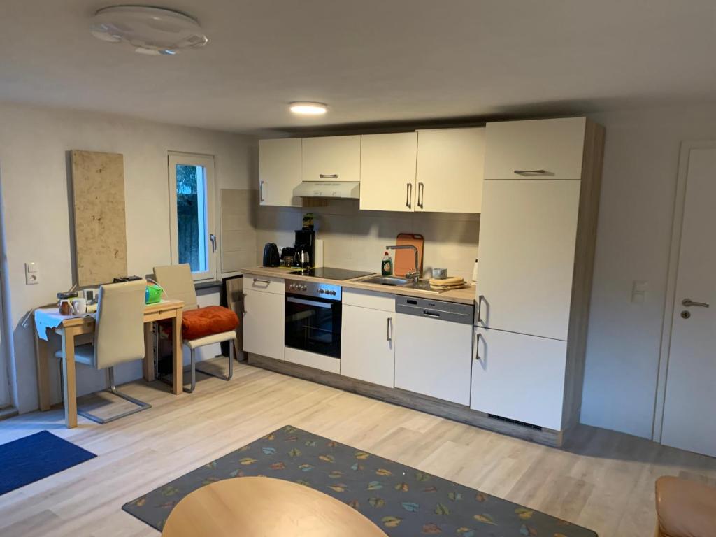a kitchen with white cabinets and a table in a room at Ferienhaus in Lassan vor Usedom in Lassan