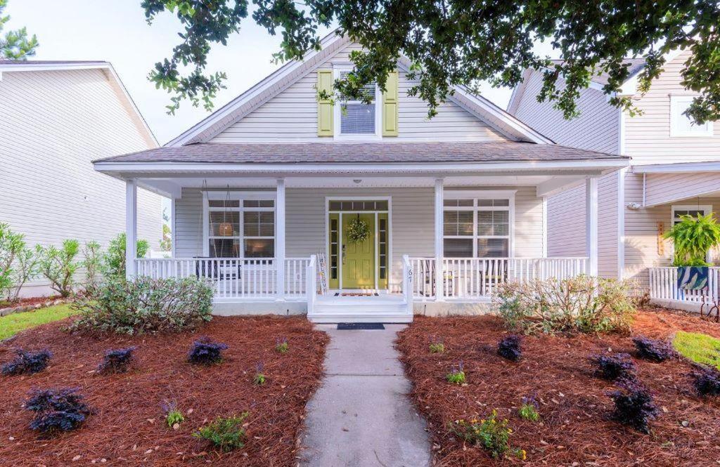 a white house with a pathway leading to the front door at Calypso Cottage in Bluffton