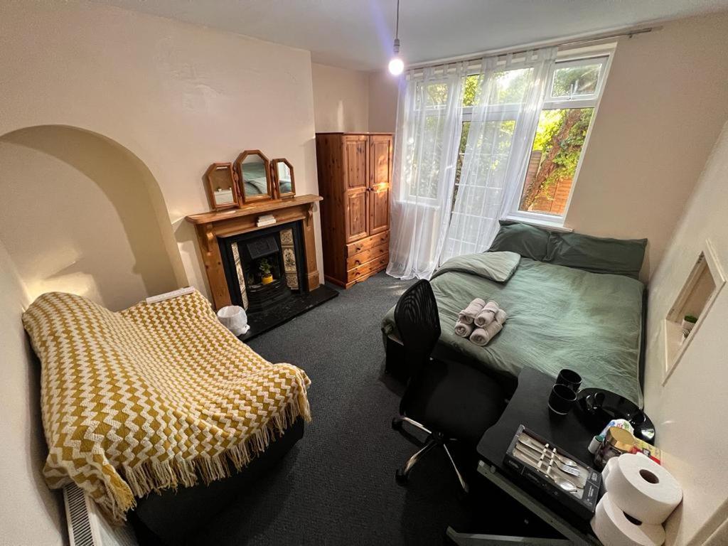 um quarto com uma cama e uma lareira em Nice Bedroom with Private Garden Woodleigh Avenue em Birmingham