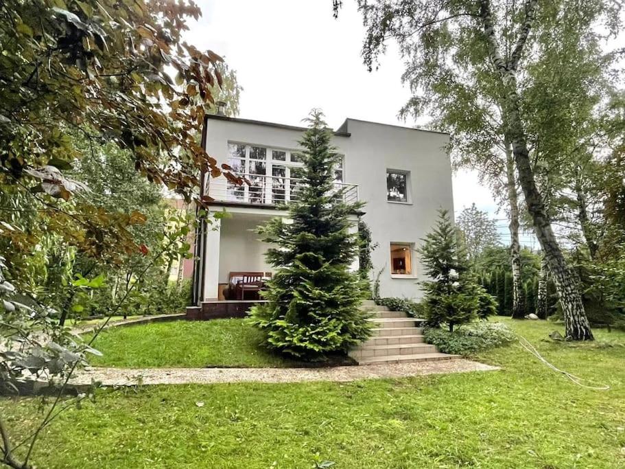una casa blanca con un árbol de Navidad en el patio en Beautiful villa with garden in Milanówek, en Milanówek
