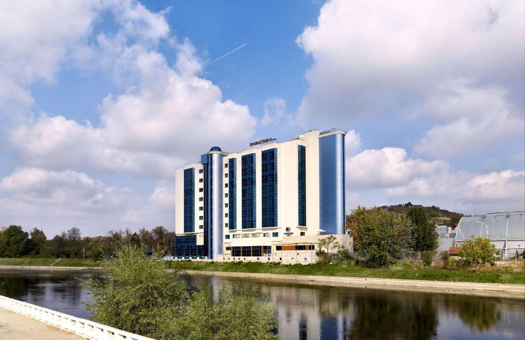 a large white building next to a river at DoubleTree by Hilton Oradea in Oradea