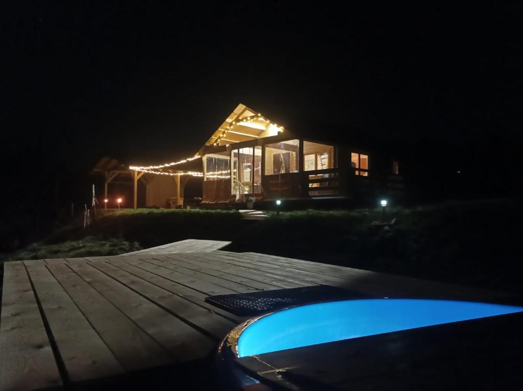 una casa iluminada por la noche con un coche aparcado delante en Lawendowy Wypas, en Mierzeszyn