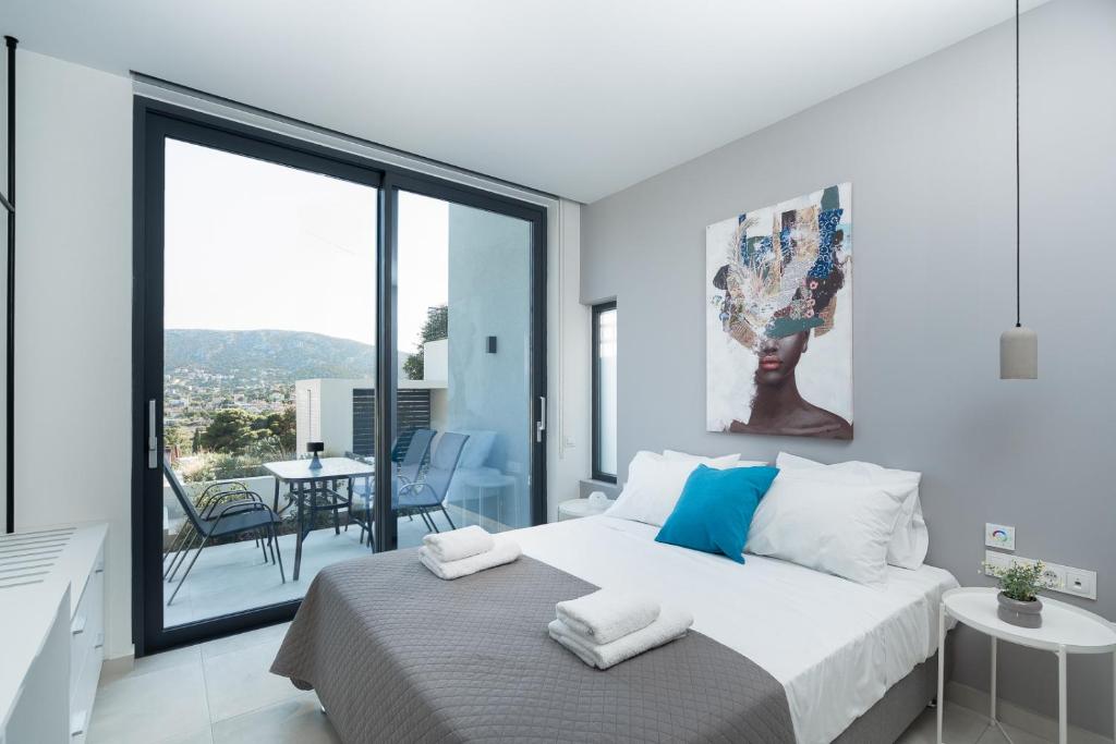 ポルト・ラフティにあるWhite Cliff Luxury Suites by A&D Propertiesの白いベッドルーム(ベッド1台、バルコニー付)