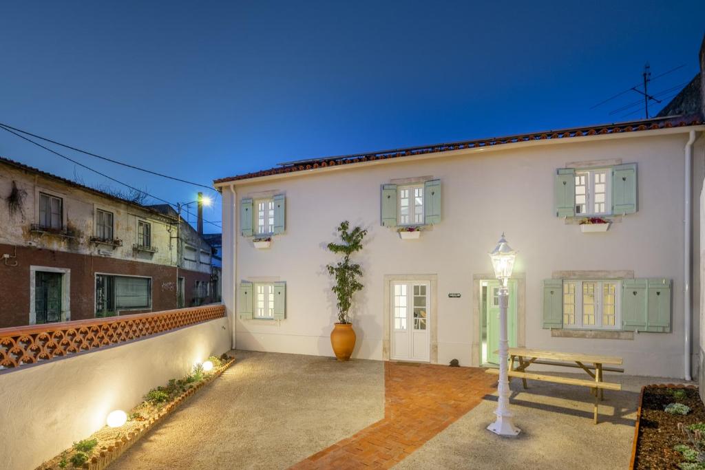 una casa bianca con panchina nel cortile di Gardenland House Leiria a Leiria