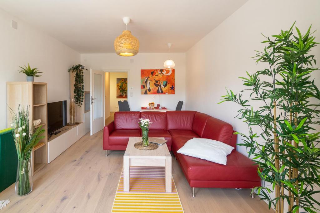 維也納的住宿－Balcony Oasis Wilhelminenberg，客厅配有红色的沙发和桌子