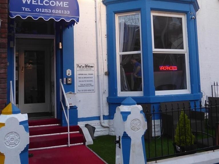 a blue and white building with a door and two parking meters at Rest and Welcome in Blackpool
