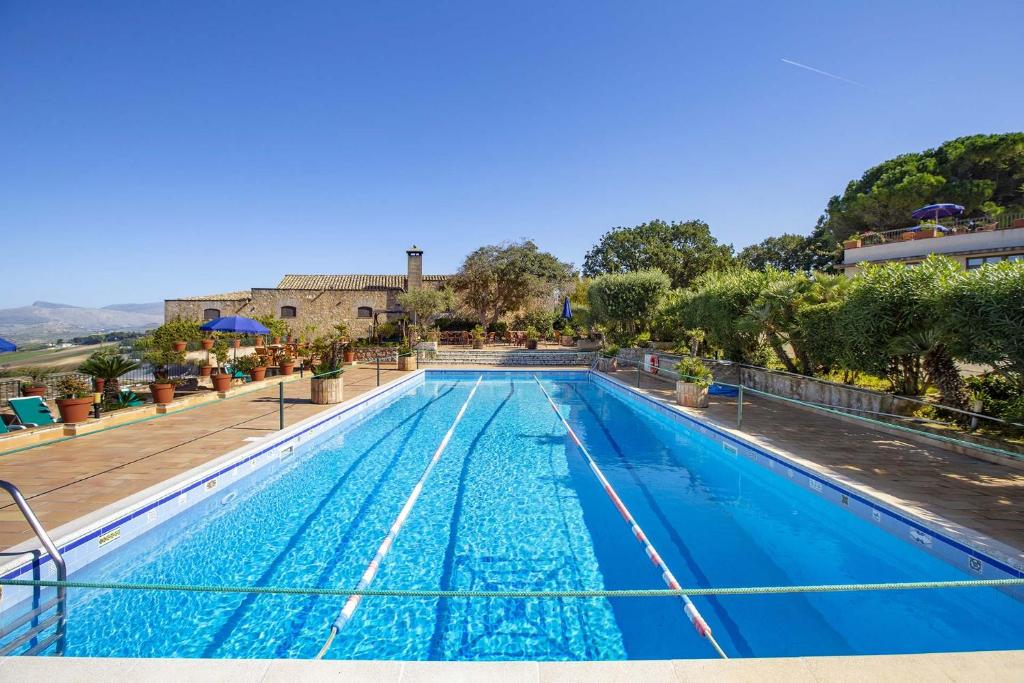 una grande piscina con acqua blu di Hotel Baglio Santacroce a Valderice