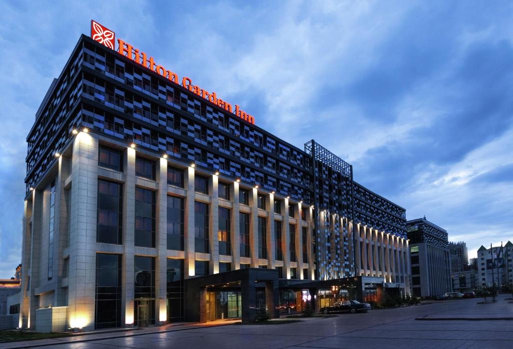 Un bâtiment avec un panneau en haut dans l'établissement Hilton Garden Inn Astana, à Astana