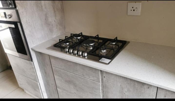 a stove top oven sitting on top of a kitchen counter at Sagewood Manor in Midrand
