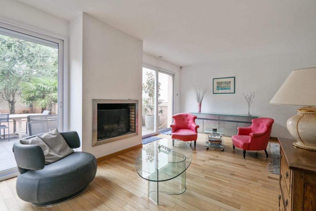 a living room with red chairs and a fireplace at Lovely house with garden Saint-Cloud near Paris - Welkeys in Saint-Cloud