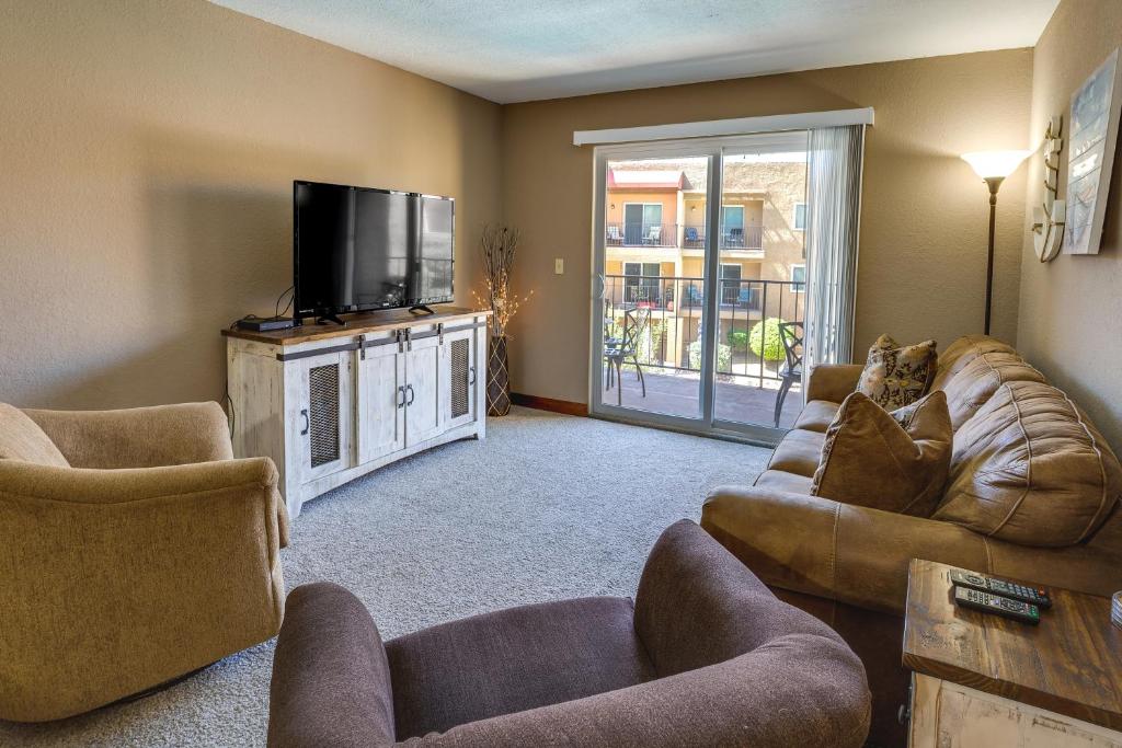 a living room with couches and a flat screen tv at Cozy Condo with Resort Perks - Half Mi to Beach! in Lake Havasu City